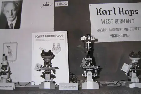 Display of Karl Kaps Microscopes made in Germany. Microscopes on display, poster visible in background.