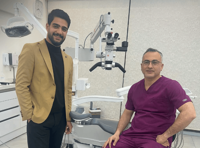 Two professionals in a dental setting stand near Karl Kaps Microscopes made in Germany. Neutral expressions.