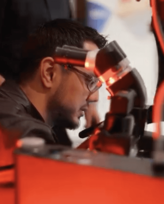 A person leans in close to Karl Kaps Microscopes made in Germany.