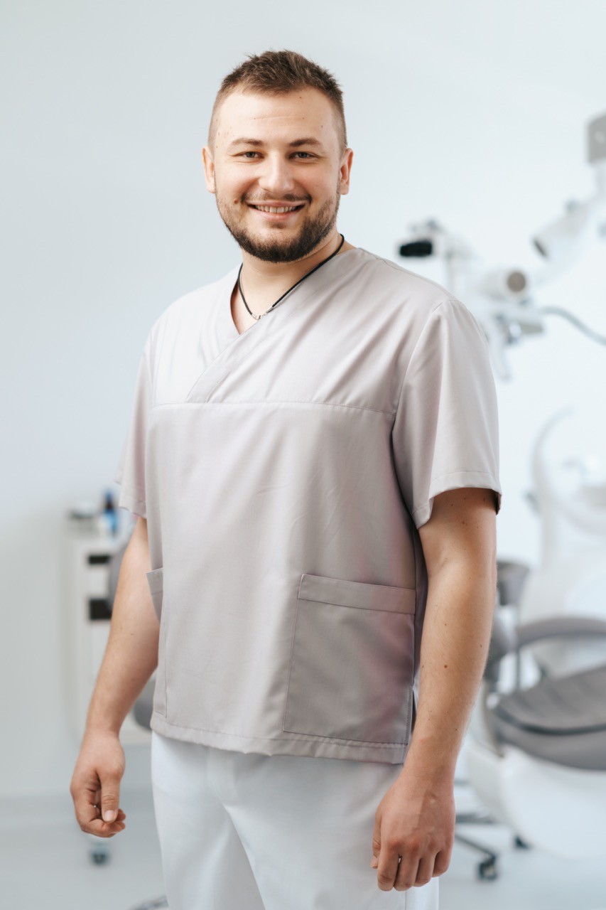Ein lächelnder Professional in hellgrauer Kleidung