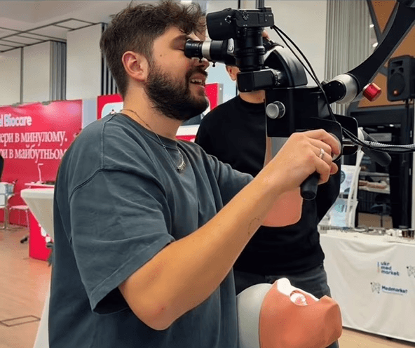 Person uses Karl Kaps Microscopes made in Germany. A medical professional uses equipment at a conference.