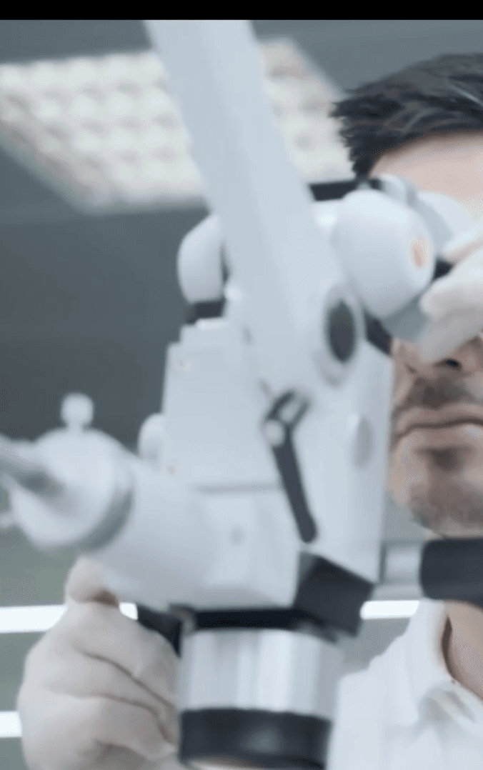 Person works with Karl Kaps "Microscopes made in Germany" equipment in lab.