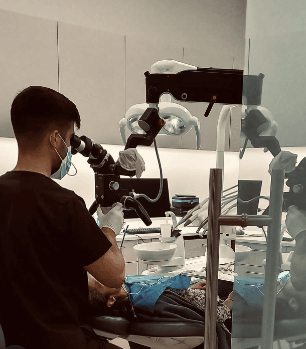 Professional using Karl Kaps Microscopes made in Germany, dental office setting.